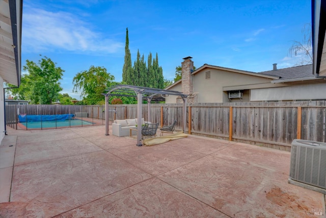 view of patio / terrace featuring central AC, a fenced backyard, outdoor lounge area, a pergola, and a wall mounted AC