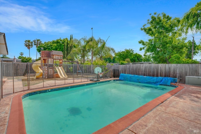 view of swimming pool featuring a fenced backyard and a playground