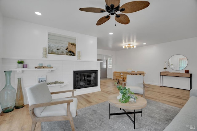 living area featuring ceiling fan, wood finished floors, a fireplace, and recessed lighting