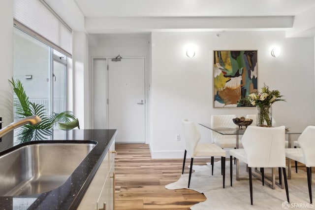 1452 Bush St Unit 9, San Francisco, CA 94109 - kitchen featuring a sink, light wood finished floors, dark stone counters, and baseboards