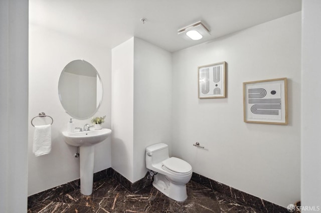 1452 Bush St Unit 9, San Francisco, CA 94109 - bathroom with marble look tile flooring, baseboards, toilet, and a sink