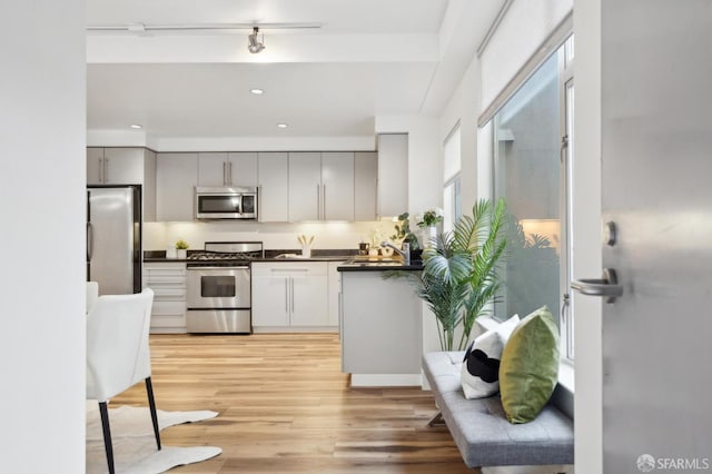 1452 Bush St Unit 9, San Francisco, CA 94109 - kitchen with appliances with stainless steel finishes, dark countertops, gray cabinets, light wood-type flooring, and recessed lighting