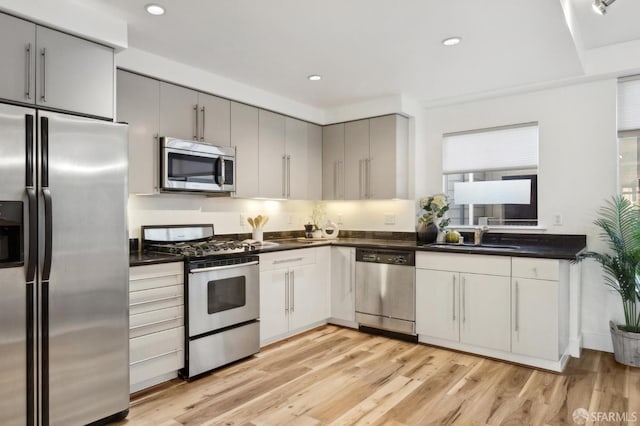1452 Bush St Unit 9, San Francisco, CA 94109 - kitchen featuring appliances with stainless steel finishes, dark countertops, gray cabinetry, light wood-style floors, and recessed lighting