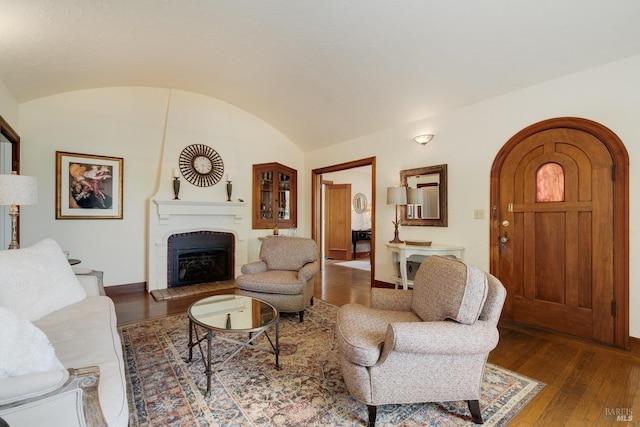 2110 3rd St, Napa, CA 94559 - living area featuring arched walkways, hardwood / wood-style flooring, baseboards, a fireplace with raised hearth, and vaulted ceiling