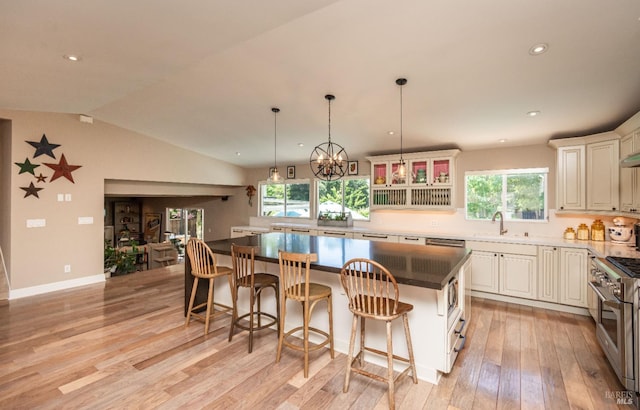3355 Covey Ct, Napa, CA 94558 - kitchen with stainless steel range, a kitchen island, light wood-style floors, a sink, and a breakfast bar