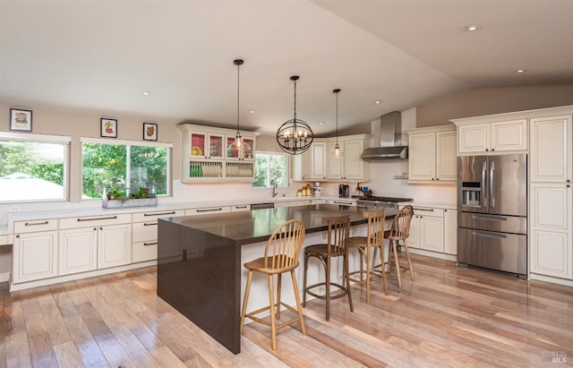 3355 Covey Ct, Napa, CA 94558 - kitchen with stainless steel appliances, wall chimney range hood, light wood-style floors, a sink, and lofted ceiling