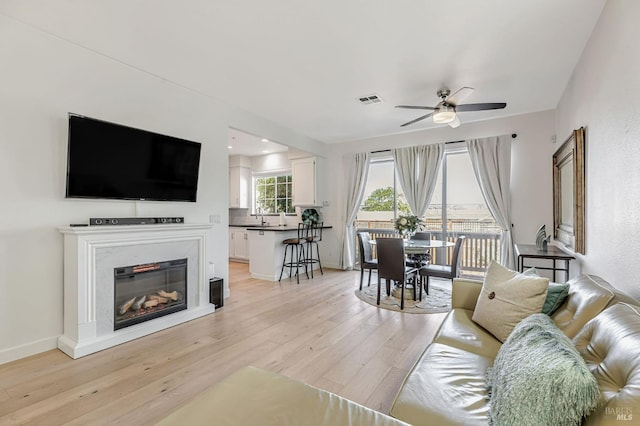 2064 Easton Dr, Petaluma, CA 94952 - living room with a ceiling fan, light wood-type flooring, and a glass covered fireplace