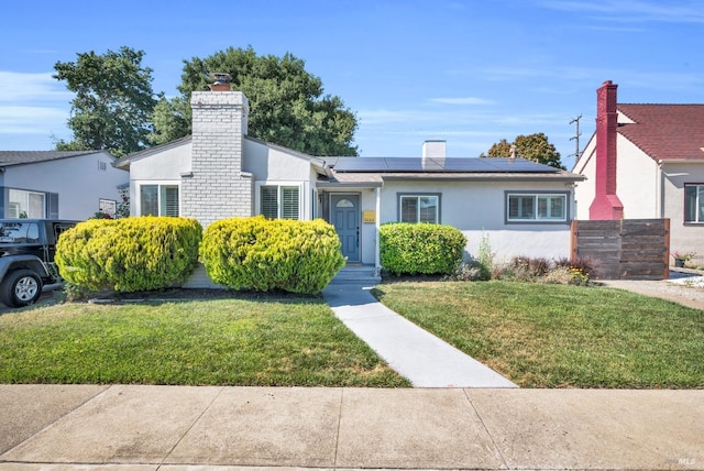 1444 Ohio St, Vallejo, CA 94590 - view of front of house featuring a chimney, roof mounted solar panels, a front lawn, and stucco siding