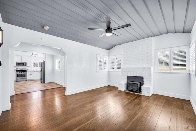 1444 Ohio St, Vallejo, CA 94590 - unfurnished living room with vaulted ceiling, ceiling fan, dark wood-type flooring, baseboards, and a wood stove