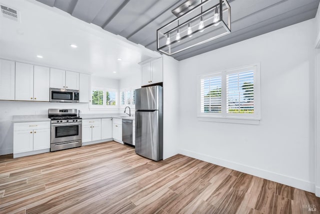 1444 Ohio St, Vallejo, CA 94590 - kitchen with appliances with stainless steel finishes, light countertops, light wood-style flooring, a sink, and white cabinets