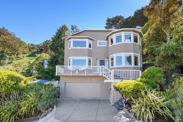 2 Spring Hill Cir, Sausalito, CA 94965 - view of front of home with a chimney, concrete driveway, a garage, stairs, and stone siding