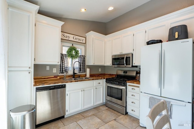 829 Winton Dr, Petaluma, CA 94954 - kitchen featuring appliances with stainless steel finishes, a sink, white cabinets, light tile patterned flooring, and recessed lighting