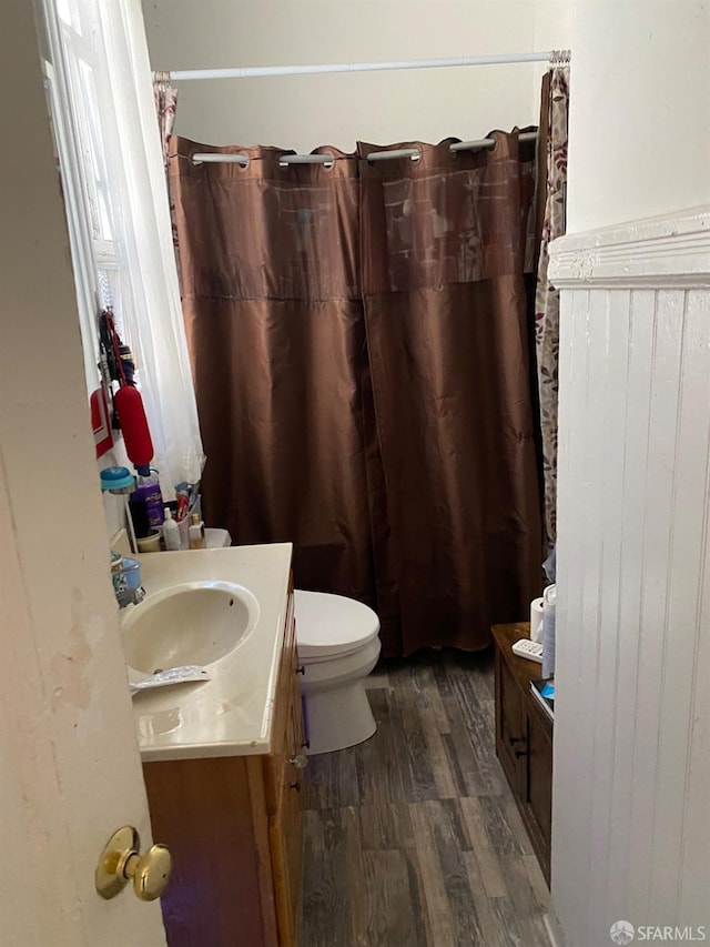 3328 26th St, San Francisco, CA 94110 - bathroom with wood finished floors, toilet, vanity, and a shower with shower curtain