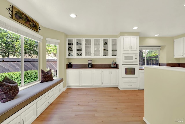 113 Pau Ct, Fairfield, CA 94534 - kitchen featuring white appliances, glass insert cabinets, white cabinetry, light wood-style floors, and dark countertops