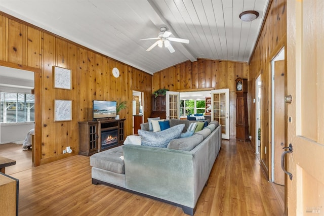 16635 Center Way, Guerneville, CA 95446 - living room featuring lofted ceiling, wood walls, light wood finished floors, ceiling fan, and a lit fireplace
