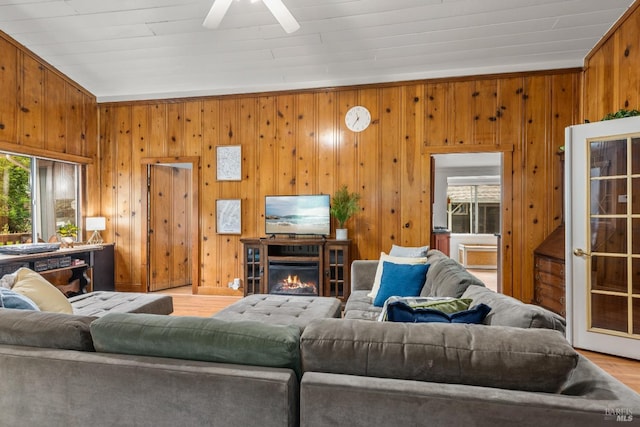 16635 Center Way, Guerneville, CA 95446 - living room featuring wood finished floors, ceiling fan, wood walls, and a lit fireplace