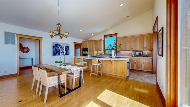 dining area featuring a chandelier, lofted ceiling, light wood-style floors, recessed lighting, and baseboards