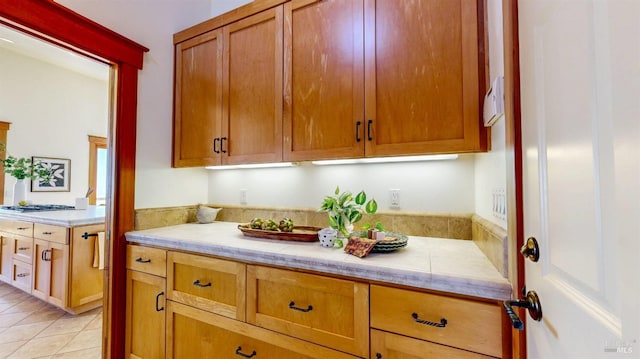 kitchen with light tile patterned floors and brown cabinets