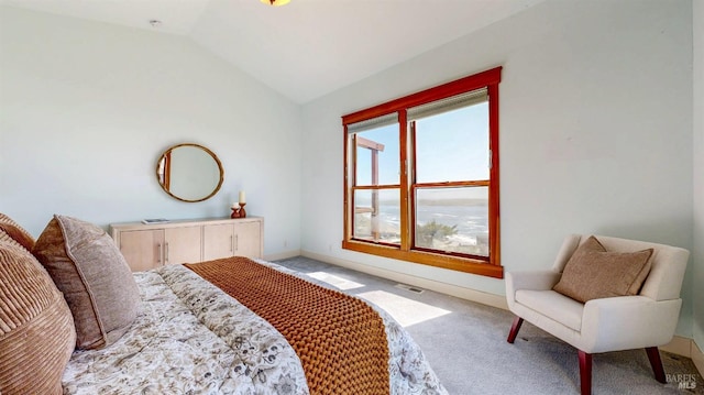 bedroom with light colored carpet, lofted ceiling, and baseboards
