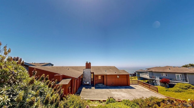 rear view of house featuring a patio, a chimney, and fence
