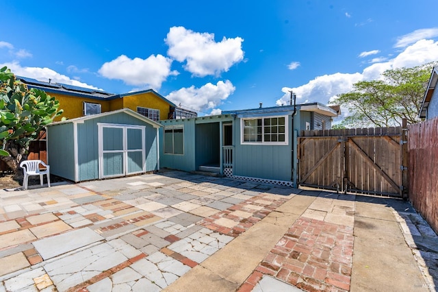 213 Sperry Ave, Vallejo, CA 94590 - rear view of house with a patio area, a storage unit, a gate, fence, and an outdoor structure