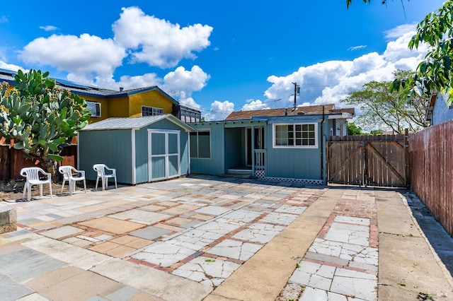 213 Sperry Ave, Vallejo, CA 94590 - back of property featuring a patio, a storage unit, a fenced backyard, and a gate
