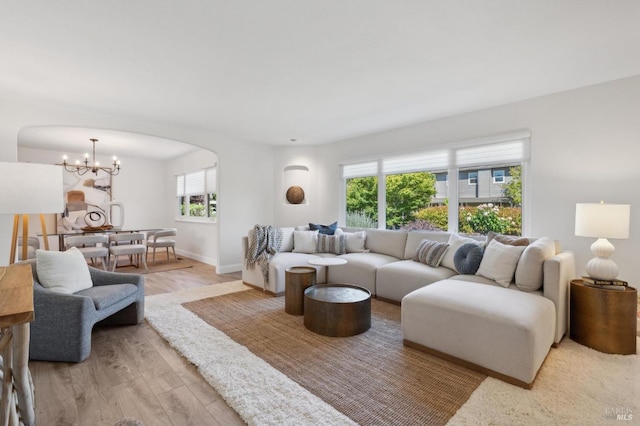 249 Los Palos St, Sonoma, CA 95476 - living area featuring light wood-style flooring, a chandelier, baseboards, and arched walkways