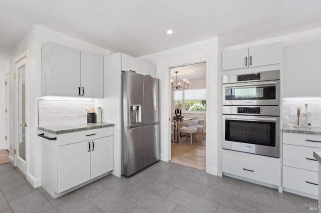 249 Los Palos St, Sonoma, CA 95476 - kitchen featuring appliances with stainless steel finishes, a chandelier, light tile patterned floors, light stone counters, and white cabinetry