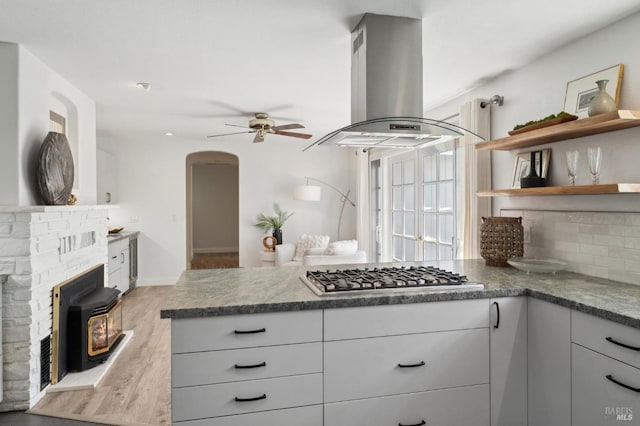 249 Los Palos St, Sonoma, CA 95476 - kitchen with island range hood, stainless steel gas stovetop, arched walkways, a ceiling fan, and open shelves