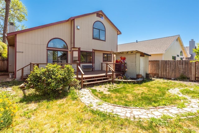 back of house featuring a wooden deck and a chimney