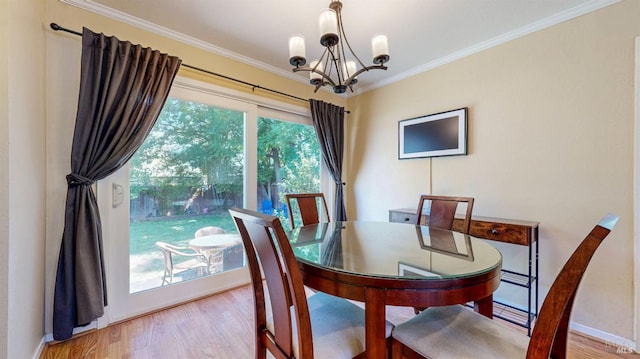 dining space with a chandelier, ornamental molding, wood finished floors, and baseboards