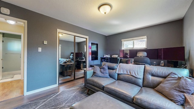 living room featuring wood finished floors, an office area, and baseboards