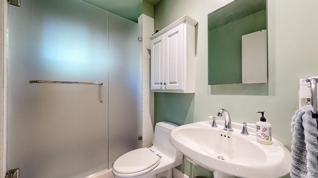 full bath featuring a stall shower, a sink, and toilet