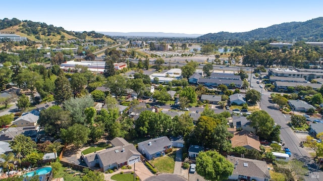 aerial view of property and surrounding area featuring a mountainous background and nearby suburban area