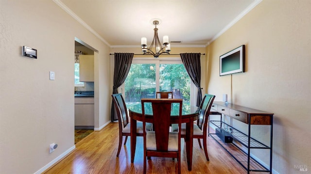 dining room with a chandelier, crown molding, light wood-style flooring, and baseboards