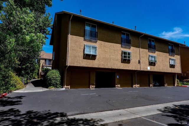 1132 Pear Tree Ln, Napa, CA 94558 - rear view of house with an attached garage, stucco siding, and asphalt driveway