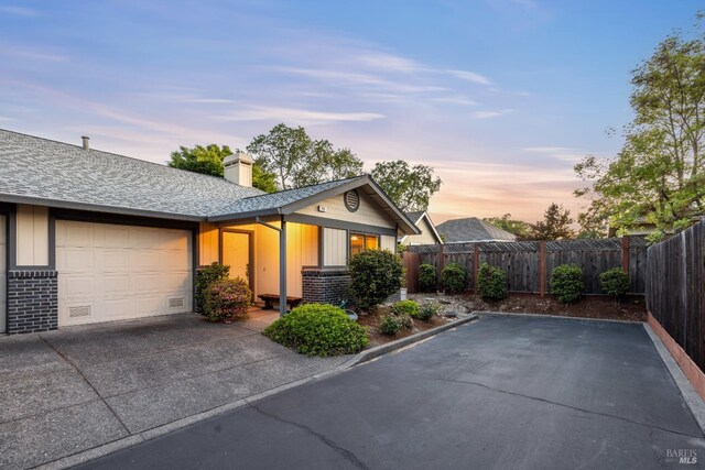 226 Usher Dr, Windsor, CA 95492 - view of front of home featuring concrete driveway, an attached garage, brick siding, a chimney, and fence