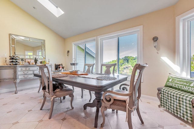 dining space featuring plenty of natural light, vaulted ceiling, a skylight, and baseboards