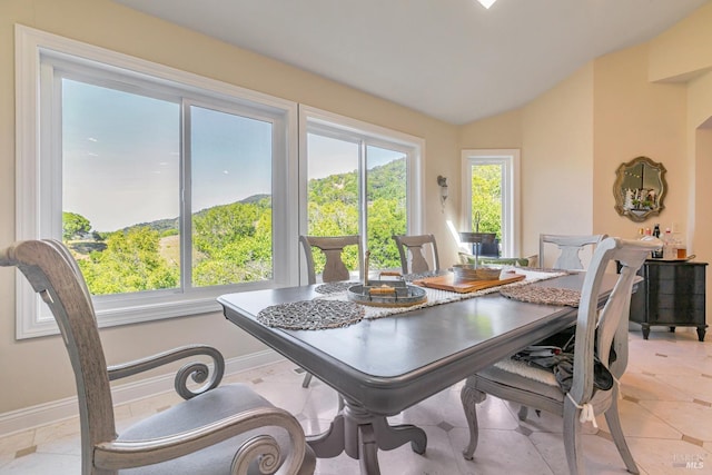 dining area featuring vaulted ceiling and baseboards