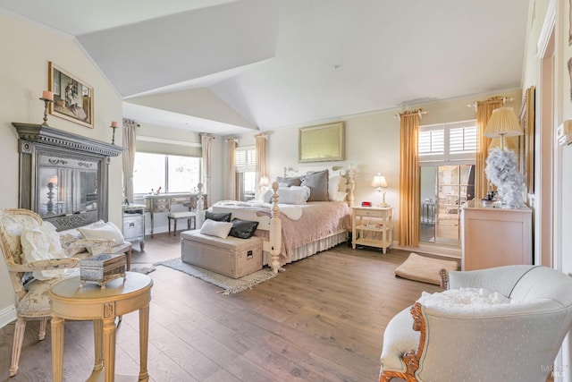 bedroom with multiple windows, wood finished floors, and vaulted ceiling