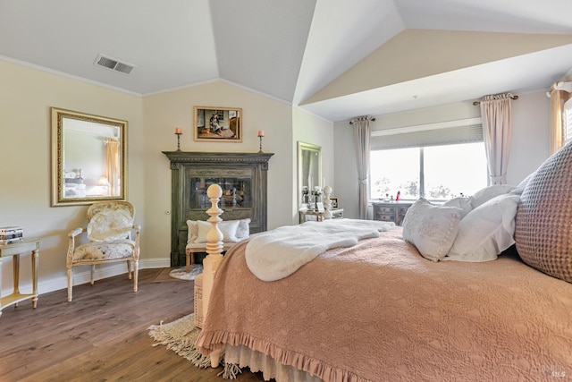 bedroom featuring wood finished floors, vaulted ceiling, multiple windows, baseboards, and a premium fireplace