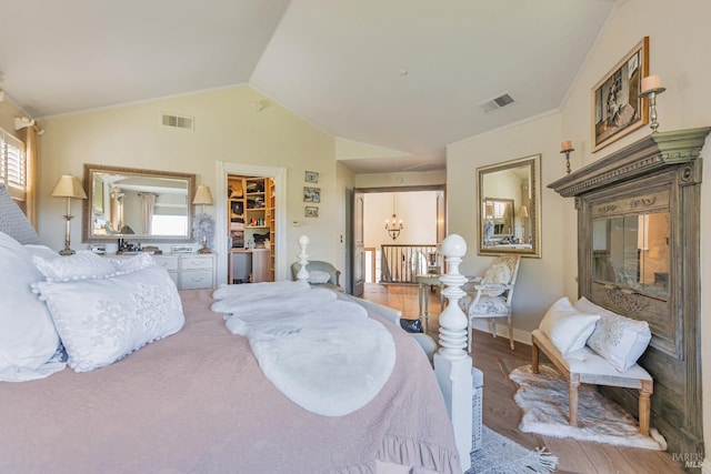 bedroom featuring wood finished floors, a chandelier, baseboards, and vaulted ceiling