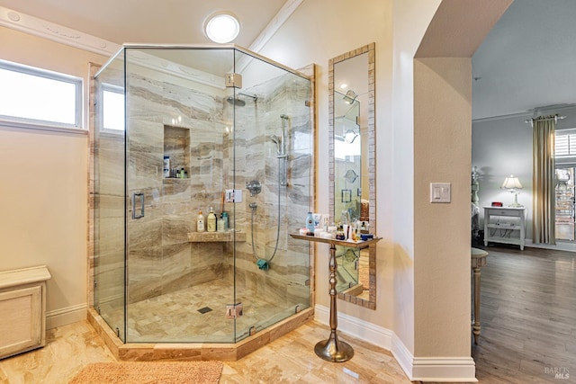 full bath with a shower stall, baseboards, and wood finished floors