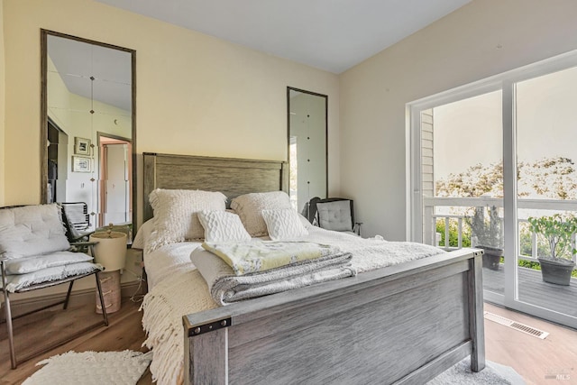 bedroom with light wood finished floors and access to outside