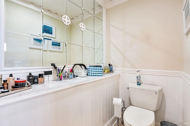 bathroom featuring toilet and wainscoting