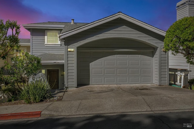 view of front of home with driveway and a shingled roof