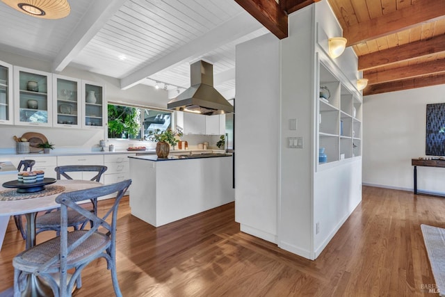 4444 Redwood Rd, Napa, CA 94558 - kitchen with island range hood, beam ceiling, wood ceiling, white cabinetry, and wood finished floors