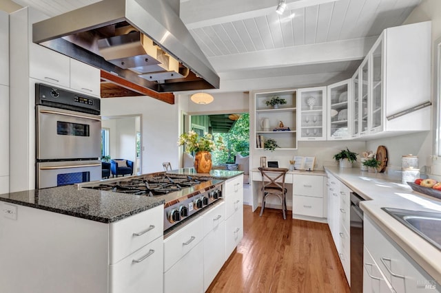4444 Redwood Rd, Napa, CA 94558 - kitchen with wall chimney range hood, appliances with stainless steel finishes, light wood finished floors, beamed ceiling, and white cabinets