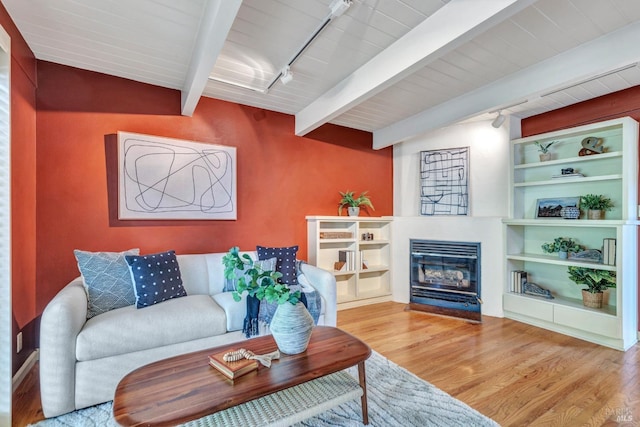 4444 Redwood Rd, Napa, CA 94558 - living area with wood finished floors, track lighting, beam ceiling, a fireplace with flush hearth, and built in shelves