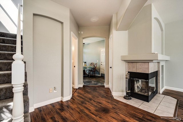 9227 Berwyn Way, Windsor, CA 95492 - living area featuring arched walkways, wood finished floors, stairway, a fireplace, and baseboards